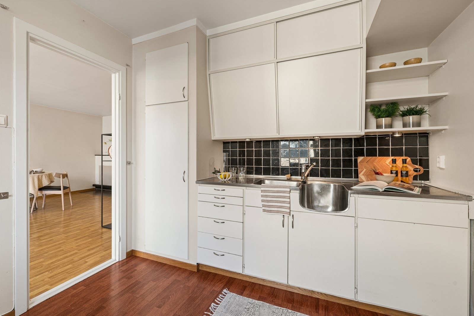 Kjøkkenet har glatte fronter og en benkeplate av stål med to vasker, samt avtrekk via sentralt avtrekksanlegg. Galleribilde