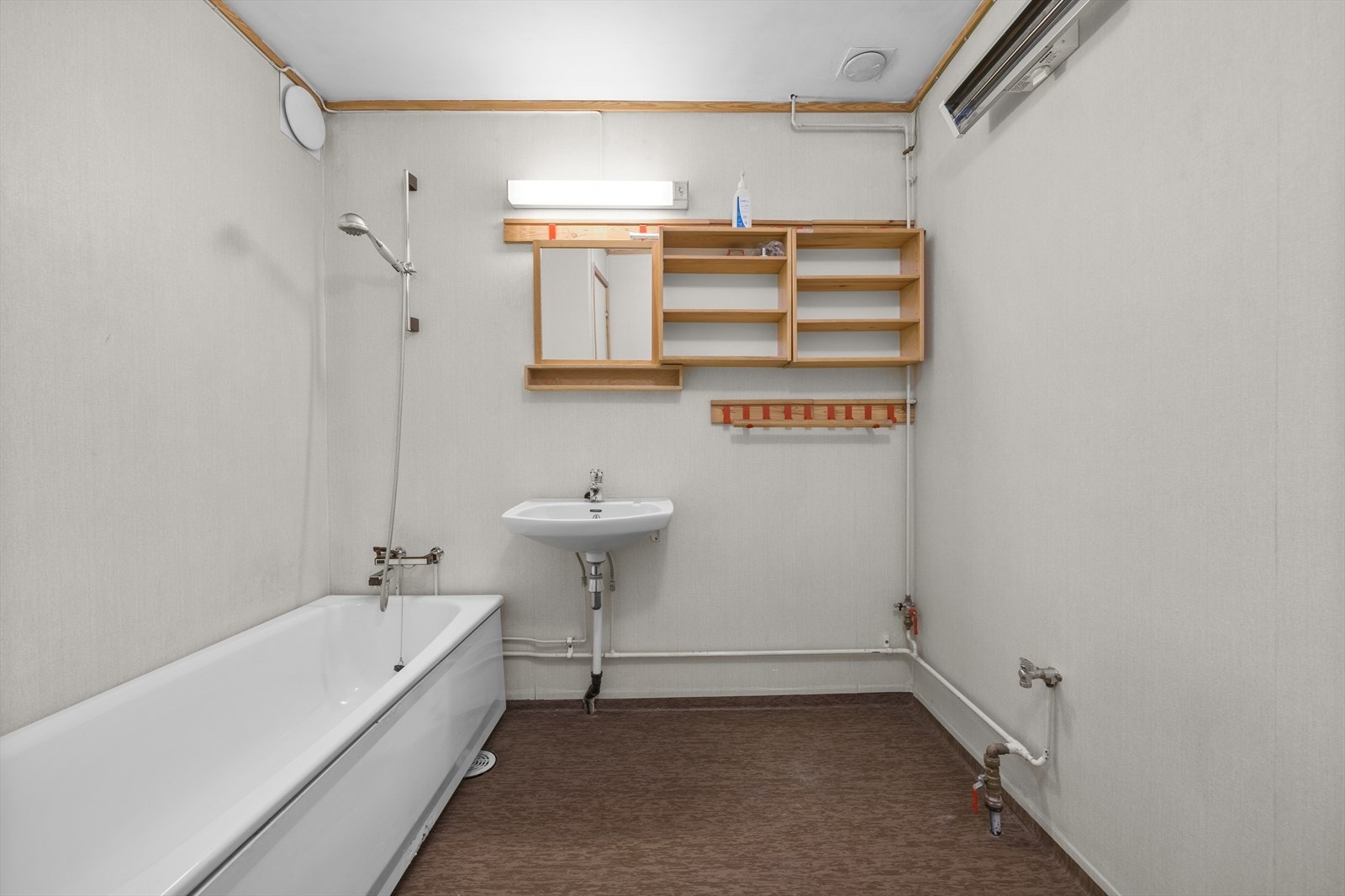 Badet i underetasjen er utstyrt med badekar og servant. Rommet har vinylbelegg på gulv. Galleribilde