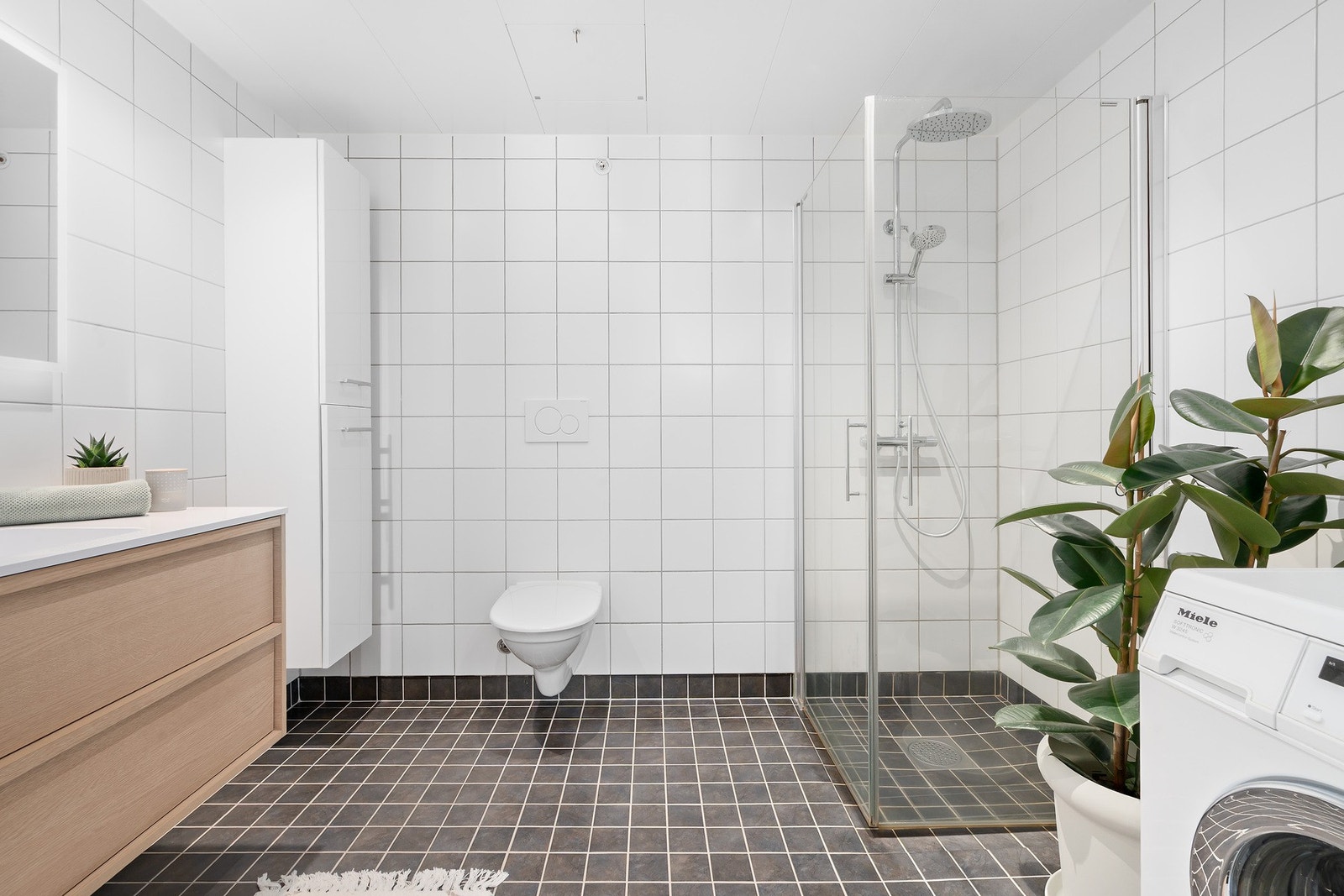 Romslig, helfliset baderom med varme i gulv og downlights i himling Galleribilde