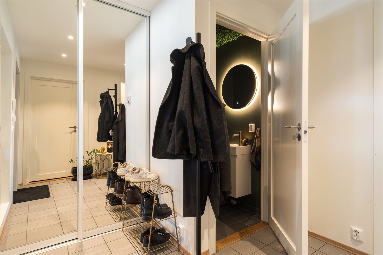 Velkommen inn i et fleksibelt familiehjem - yttertøyet ryddes vedd i en praktisk skyvedørsgarderobe. Galleribilde