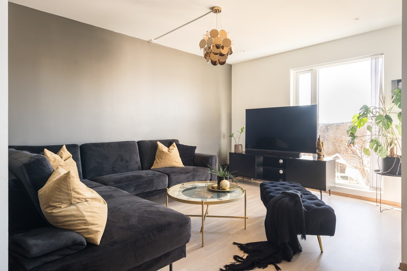 Dagslyset i stuen suppleres ypperlig av downlights i deler av taket. Parkett er lagt på gulvet, mens veggene er malt i hvitt og en mørk gråtone. Galleribilde