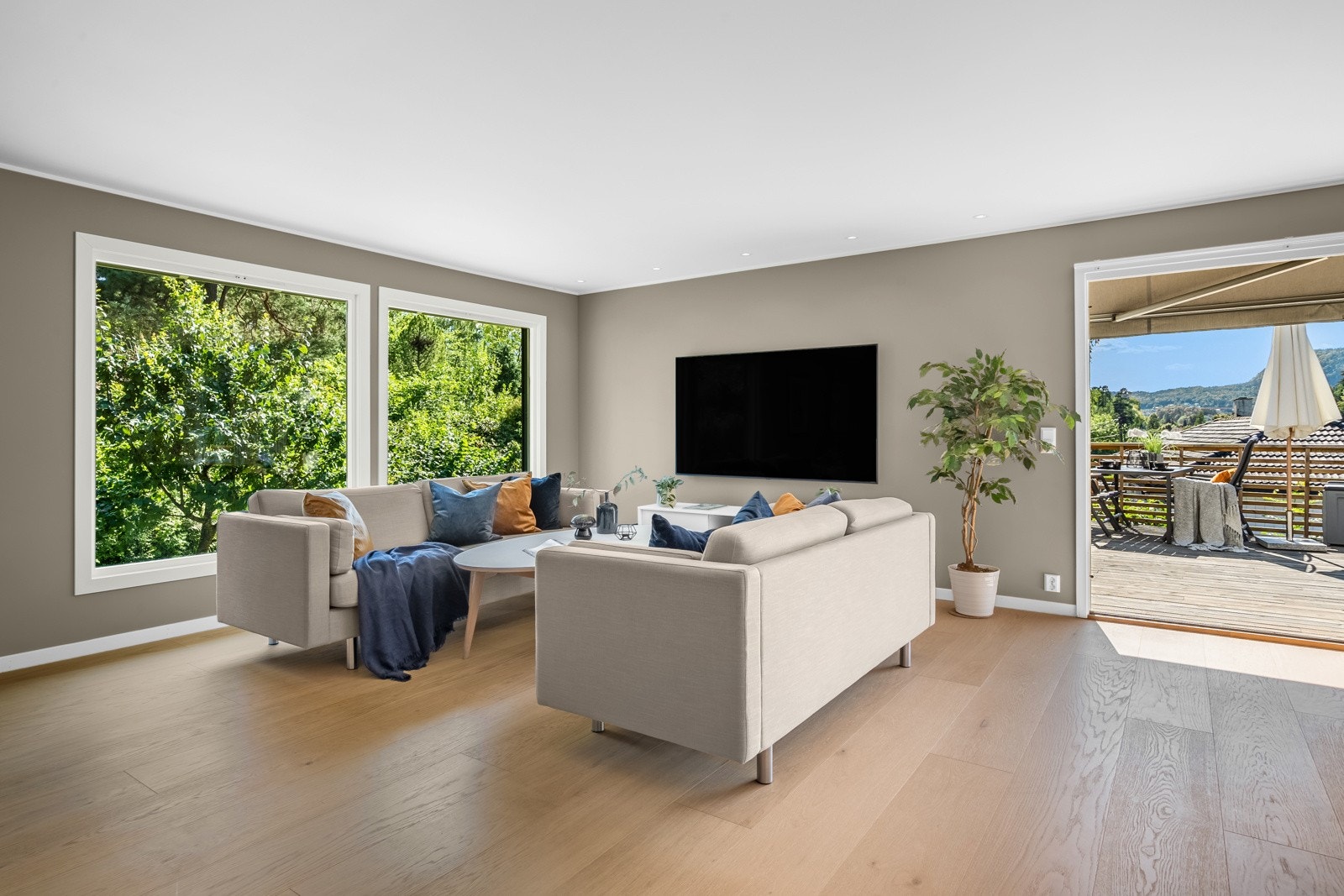 Stuen oppleves som svært luftig med tidsriktige fargevalg, store vindusflater og 1-stavs parkett med varmefolie Galleribilde