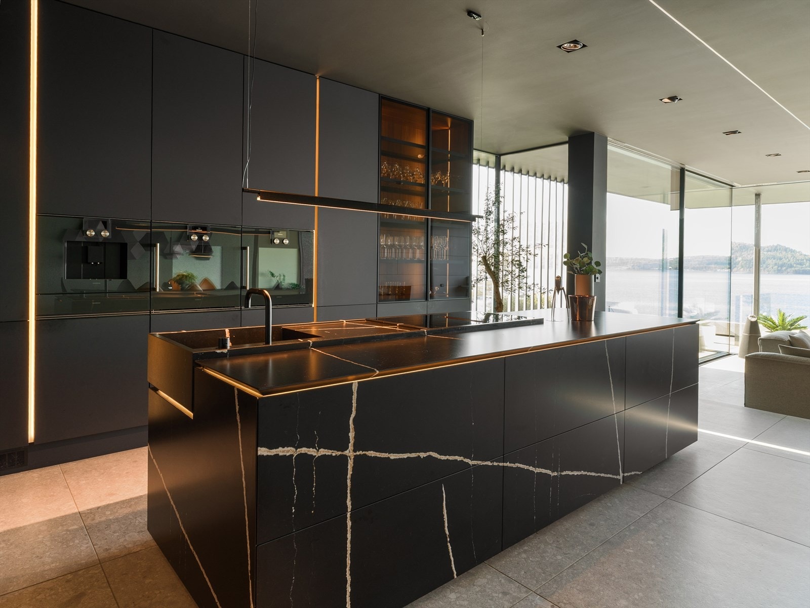 Kjøkkenøy i Silestone - Unike kjøkkenøy er kledd i eksklusive Silestone-plater, og rommer både nedfelt vask og induksjonstopp med integrert avtrekk - et visuelt og funksjonelt midtpunkt. Galleribilde