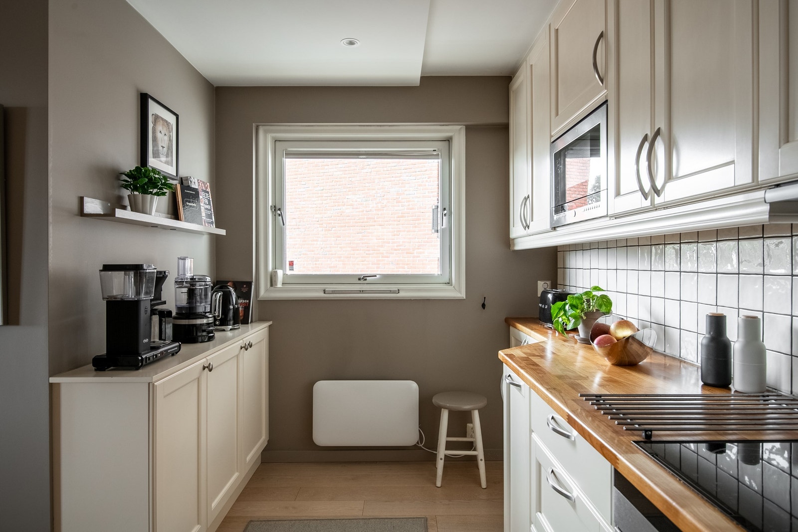 En praktisk krok gir ekstra arbeidsflate og oppbevaring, og alle hvitevarer medfølger. Galleribilde