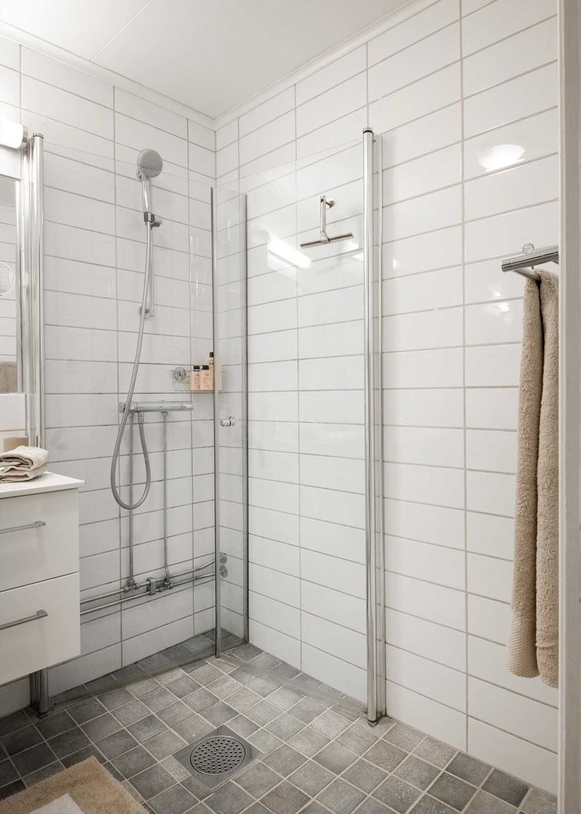 Dusjhjørne med innfellbare glassdører frigjør gulvplass når dusjen ikke er i bruk. Galleribilde