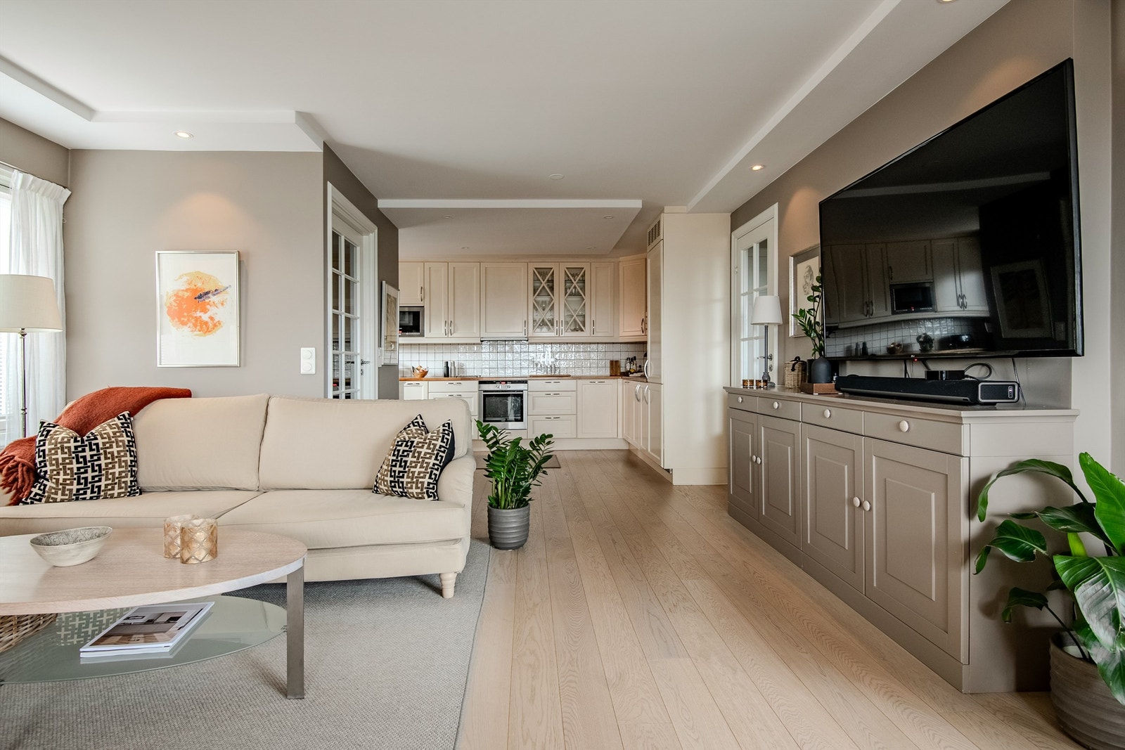 Den åpne løsningen mellom stue og kjøkken bindes sammen av en gjennomgående 1-stavs eikeparkett, lagt i 2017. Galleribilde