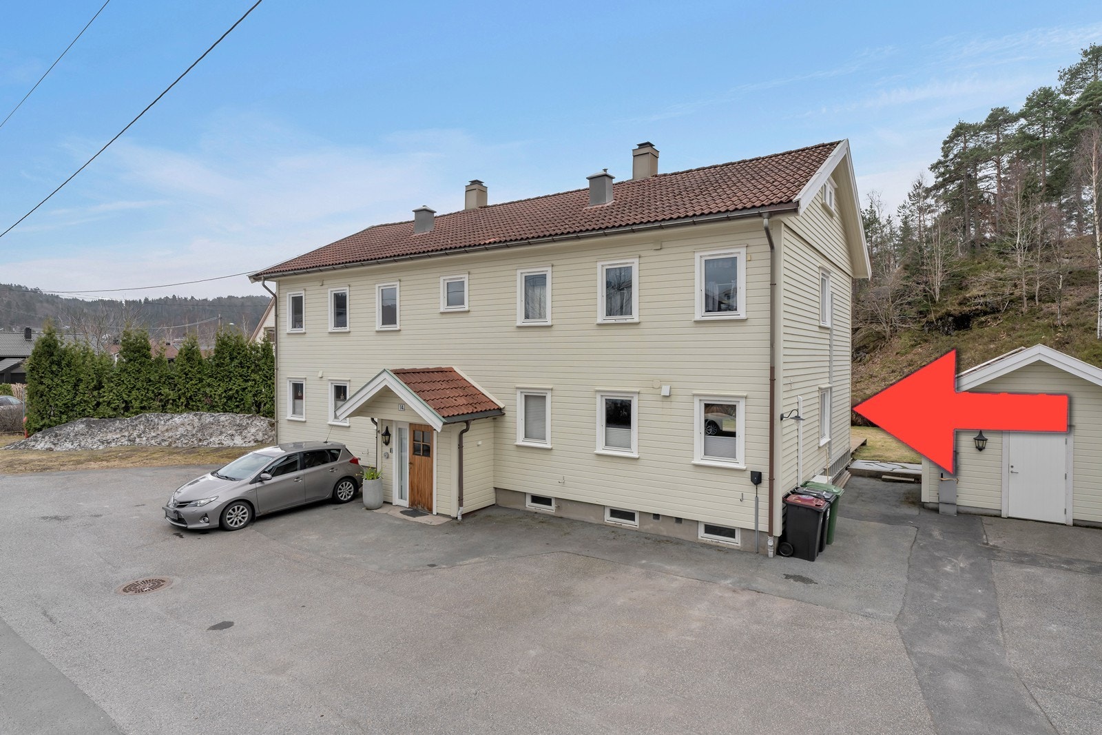 Fasade - leiligheten er markert. Felles tomt for borettslaget hvor eiligheten disponerer en biloppstillingsplass med el - billader. Det er også felles utebod til redskaper. Galleribilde