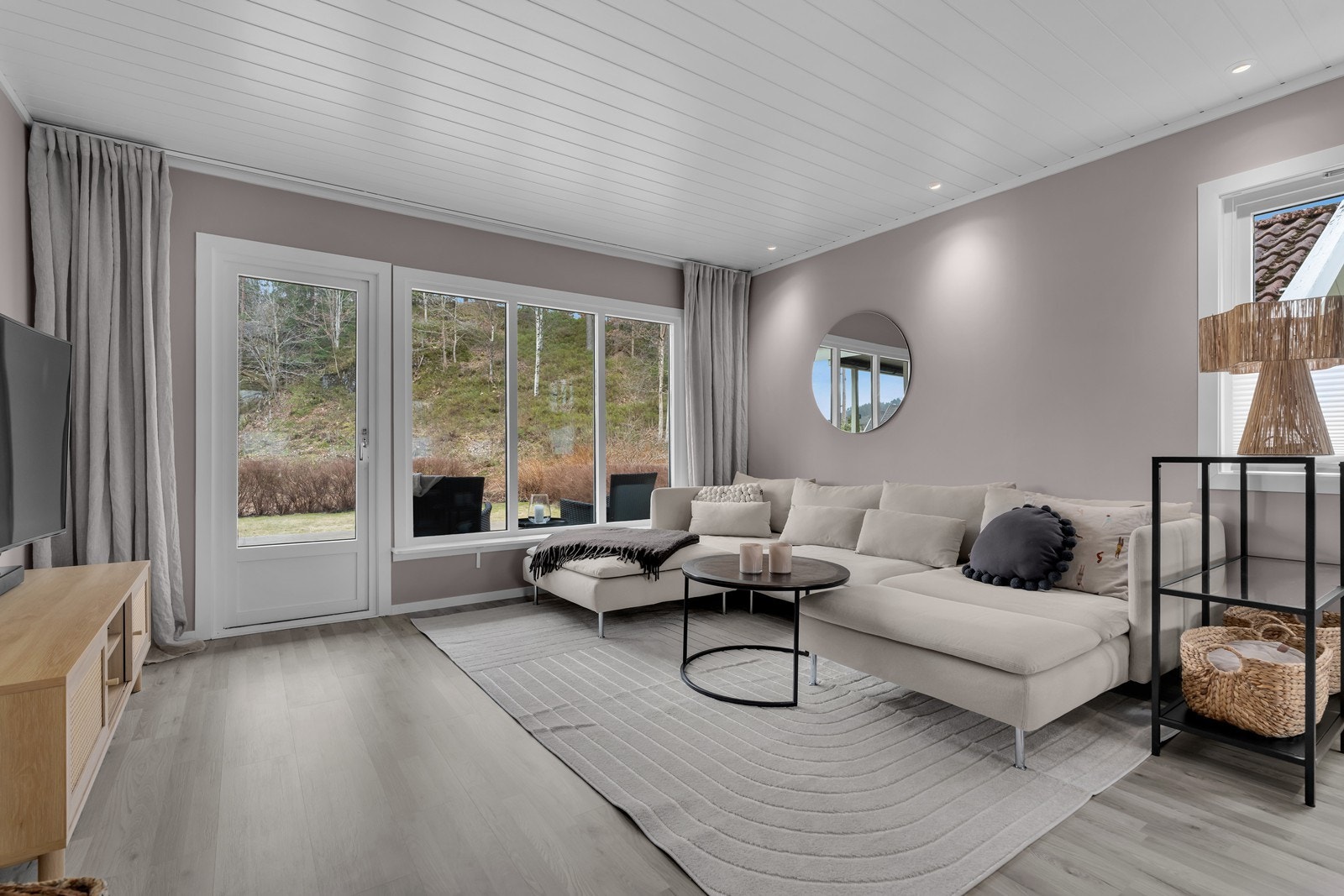 Romslig stue med plass til sofagruppe med tilhørende møblement og mediemøblement. Spotter langs tak og store vindusflater Galleribilde