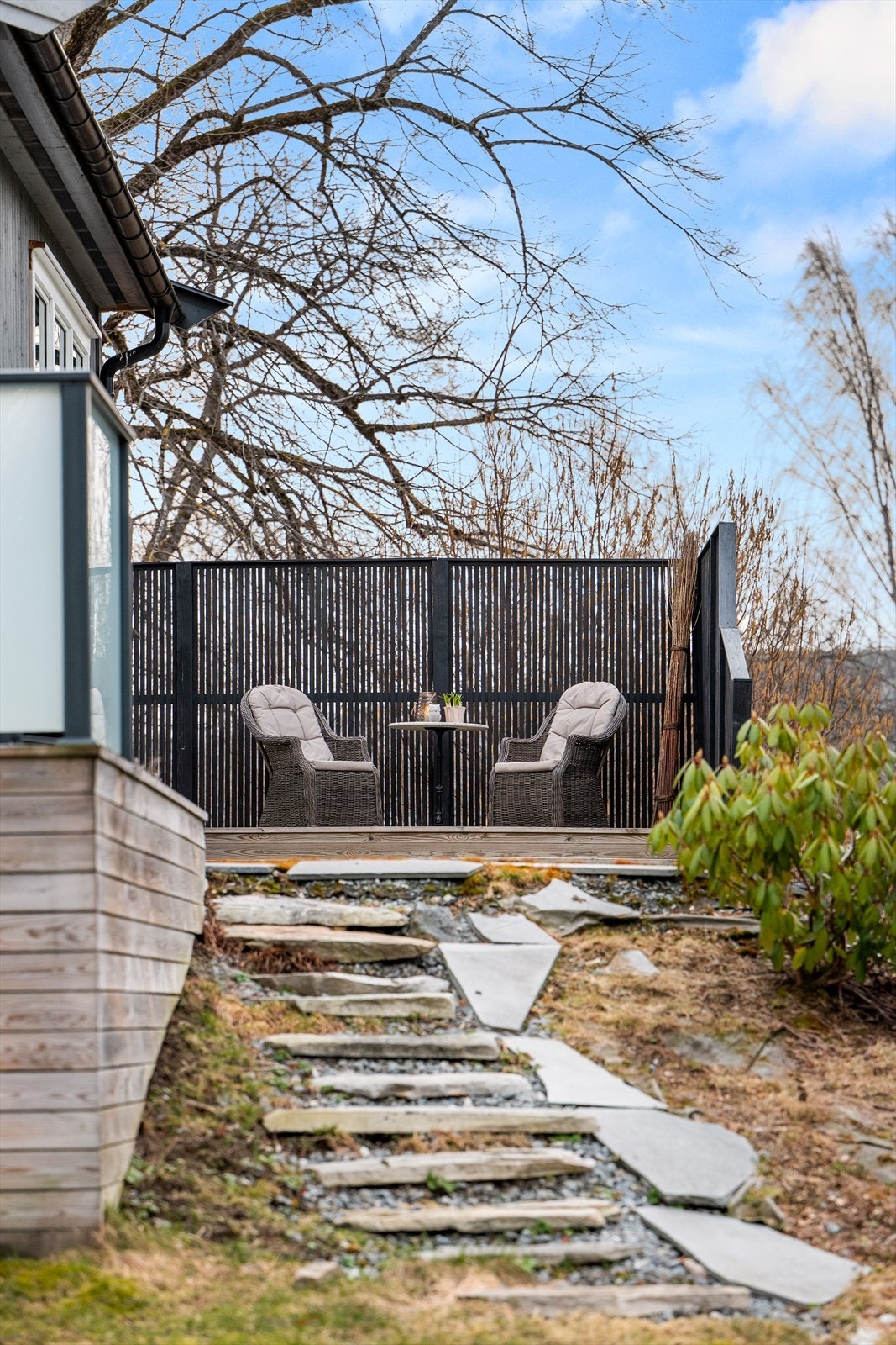 En liten, tilbaketrukket uteplass med trapp ned til hagen. Galleribilde