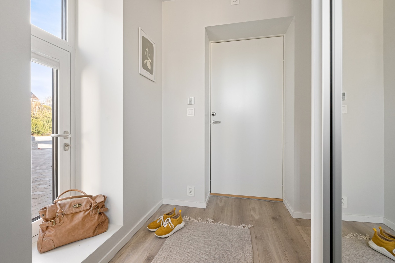 Entréen er romslig og innbydende, med store vindusflater som slipper inn rikelig med naturlig lys og gir et lyst og luftig førsteinntrykk. Galleribilde
