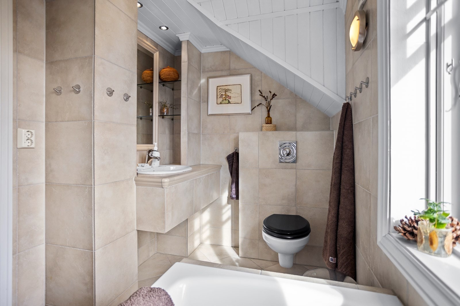 Badet i 2. etasje inneholder også blant annet veggmontert toalett med skjult sisterne og stiltilpasset og flislagt servantanretning med nedfelt vask. Galleribilde