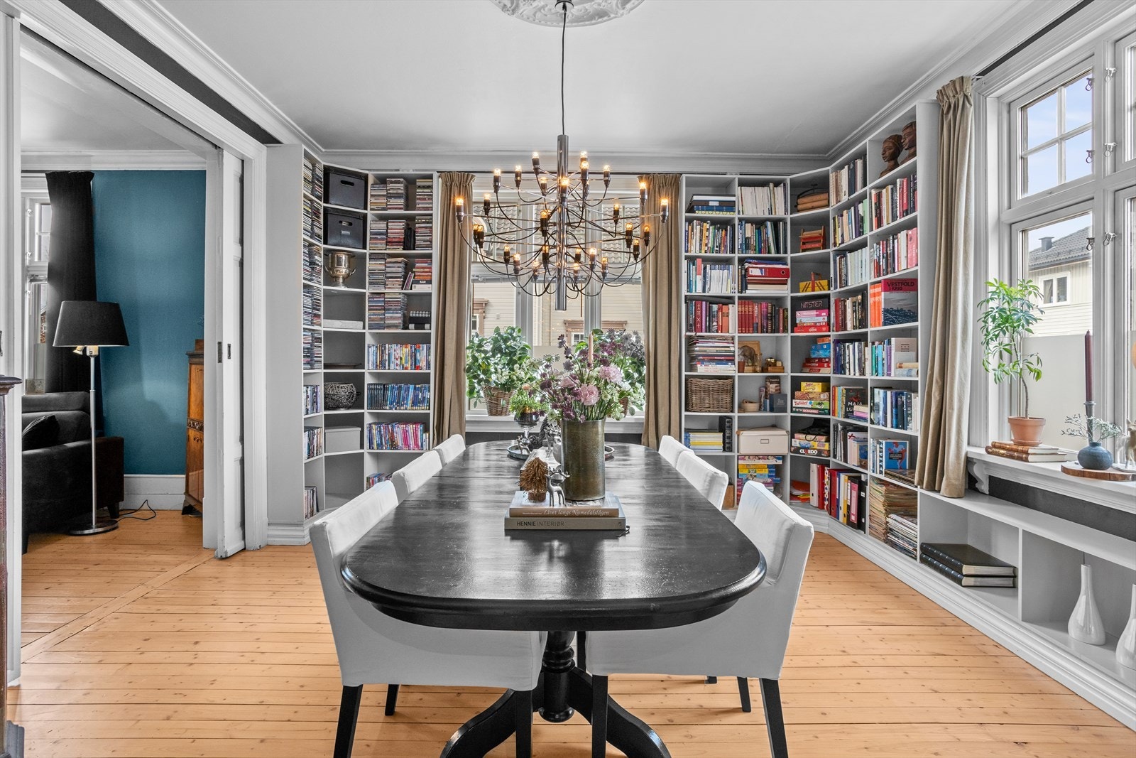Romslig og lys spisestue med store vinduer, innebygde bokhyller og muligheten for å ha en elegant lysekrone fra taket. Perfekt for både hverdagsliv og selskap. Galleribilde