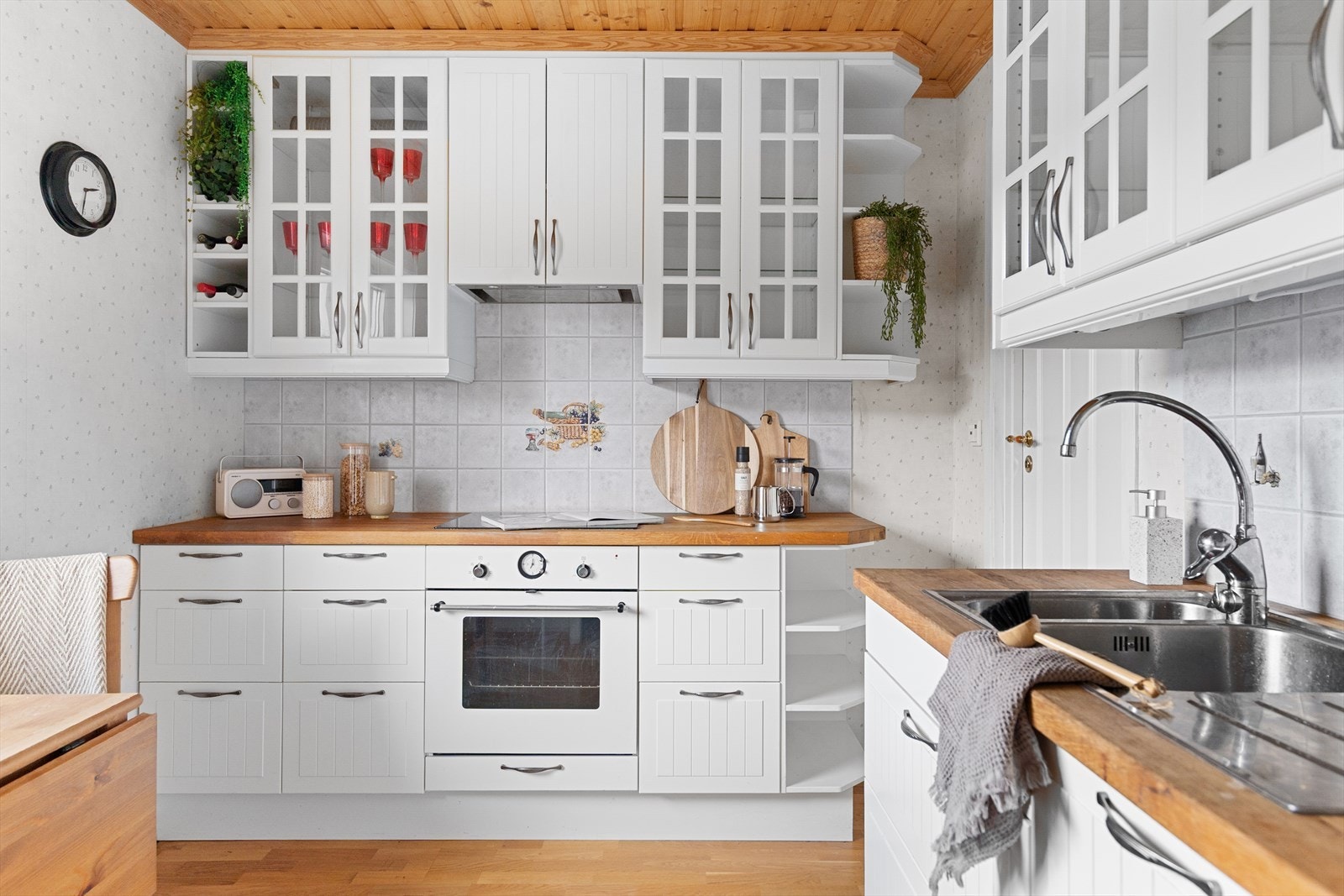 Ikea kjøkkeninnredning med hvite profilerte fronter, takhøye skap og eik benkeplate. Galleribilde