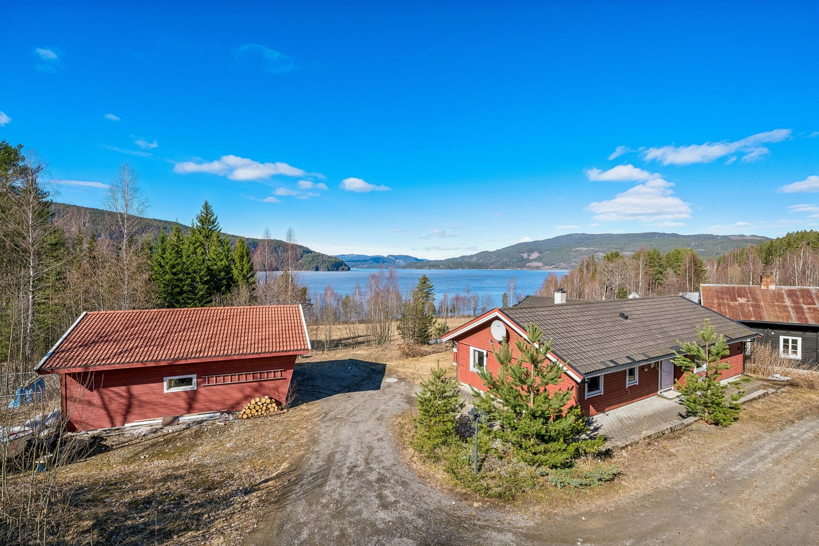 Tomten opparbeidet med støttemur mot vei, belegningsstein, plen og beplantning. Galleribilde