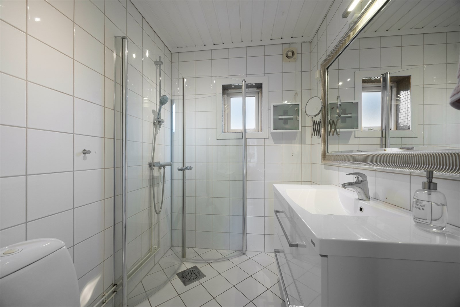 Lyst, flislagt baderom av god størrelse, med varmekabler i gulv. Badet har romslig og lyst servantskap, med heldekkende servantplate. Galleribilde