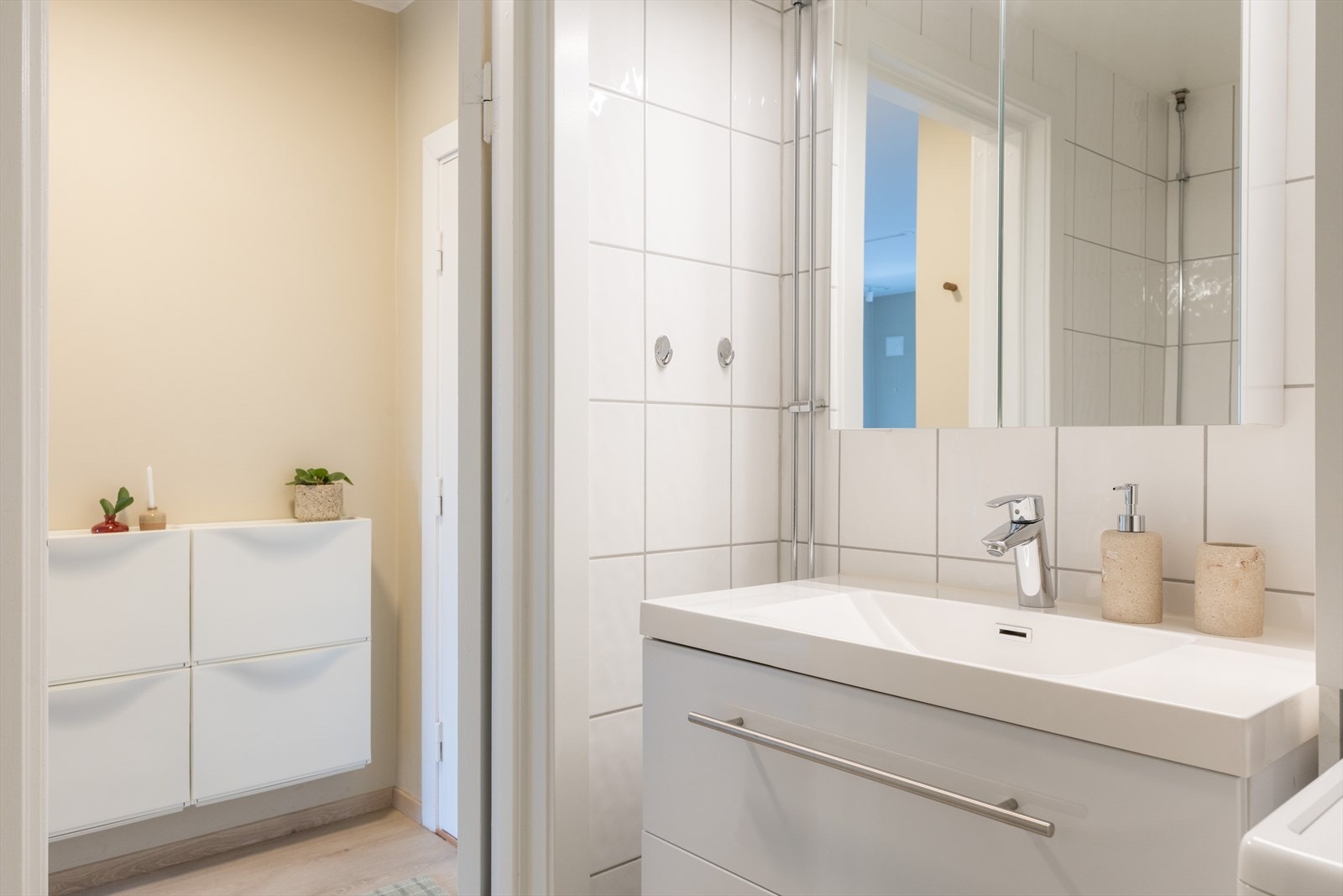 Badet er innredet med klosett, servant med innredning, speilskap med lys og dusjhjørne med svingbare glassdører. Galleribilde