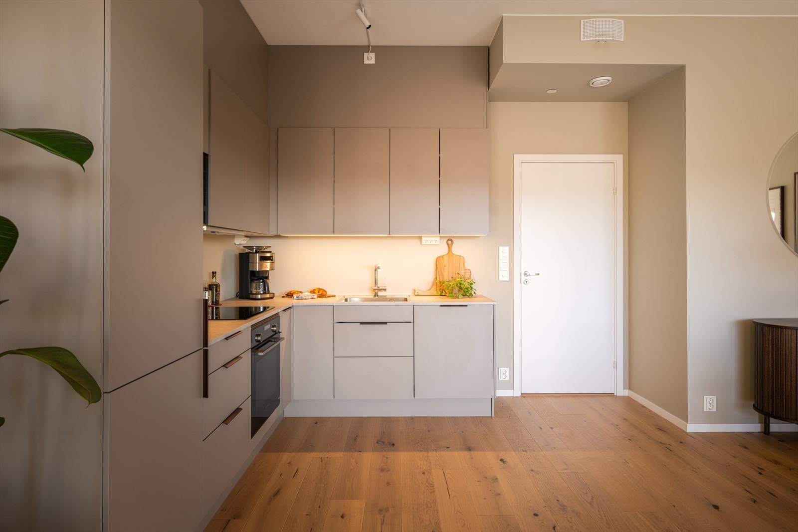 Lekkert med moderne, glatte fronter, kompositt benkeplater og integrerte hvitevarer. Galleribilde