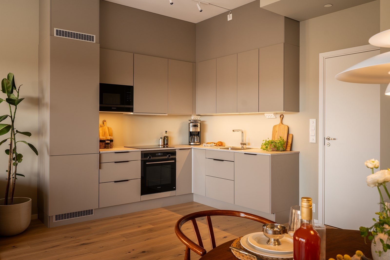 Kjøkkenet ligger i en åpen løsning mot stuen, med en praktisk utforming som gir rikelig med skap- og benkeplass. Galleribilde