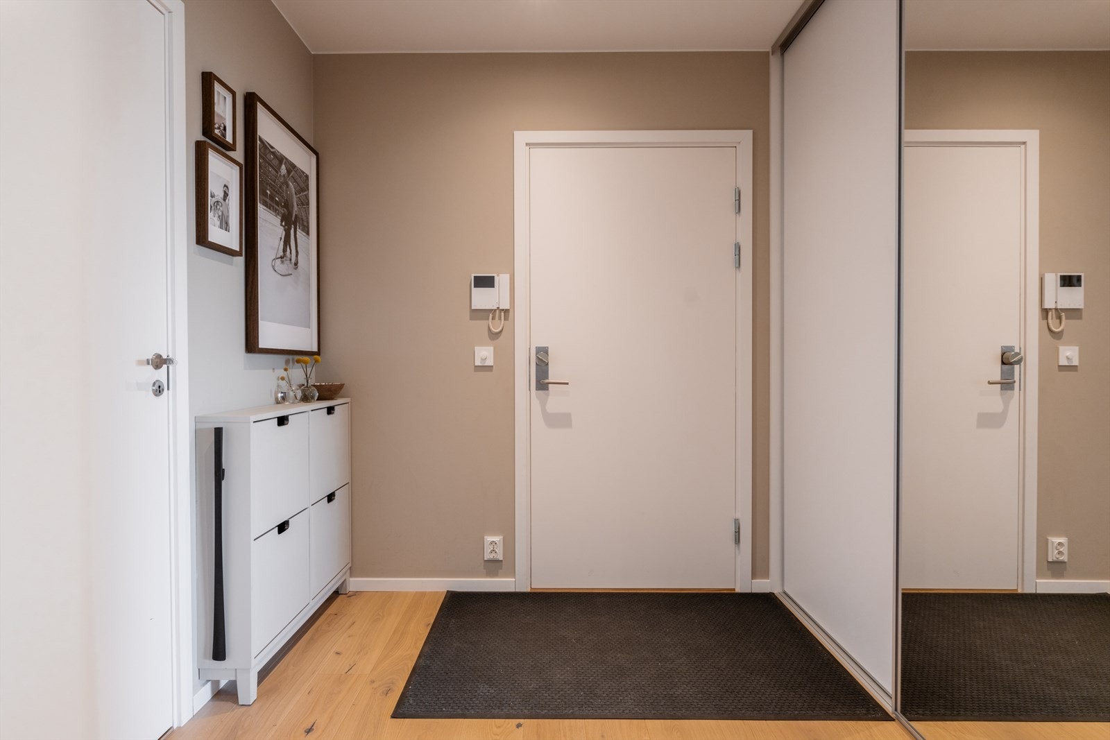Innbyende entré med stor skyvedørsgarderobe med speilfronter, som bidrar til en praktisk og ryddig hverdag. Galleribilde