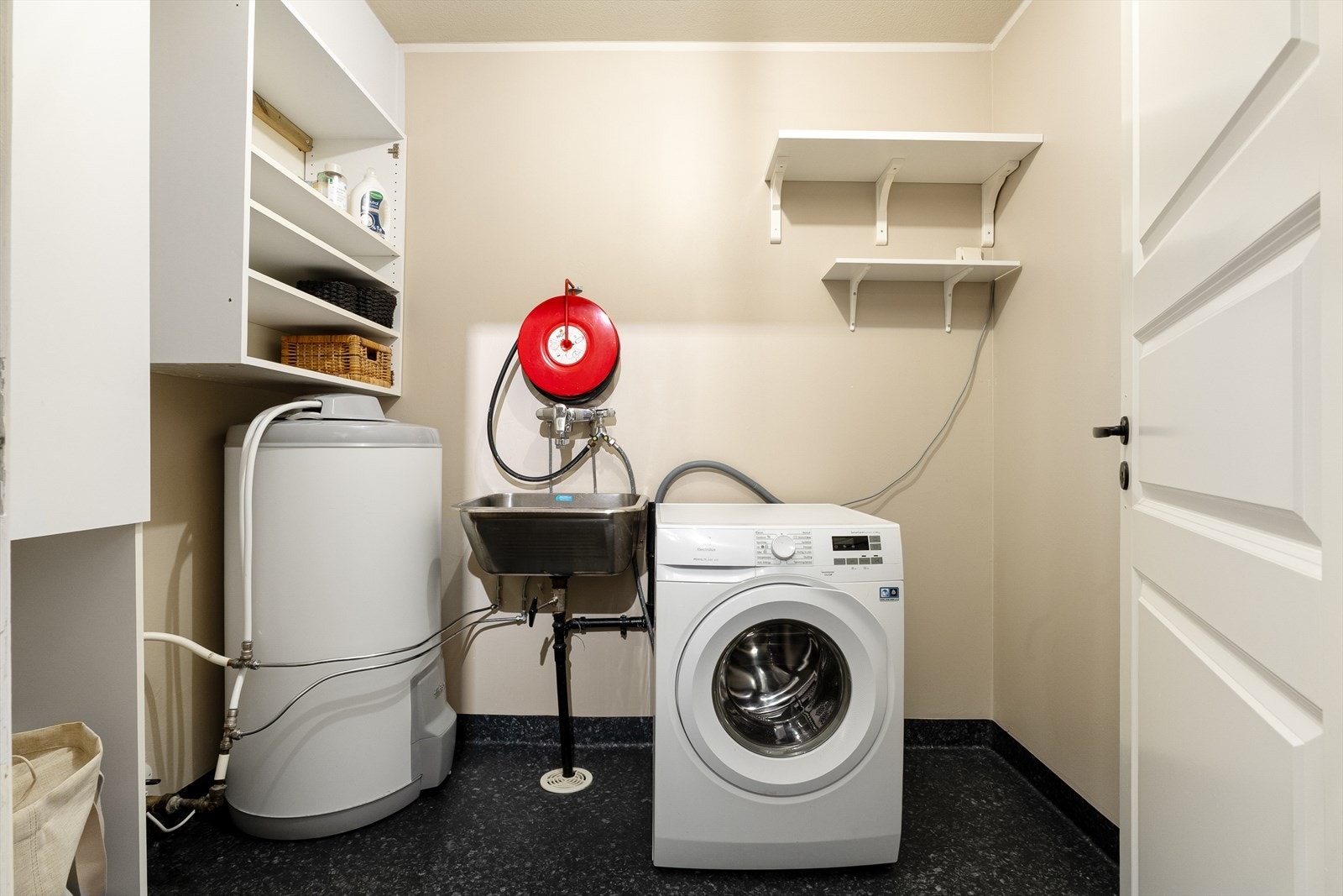 Vaskerommet er innredet med stålkum, varmtvannsbereder, husbrannslange og opplegg for vaskemaskin. Galleribilde