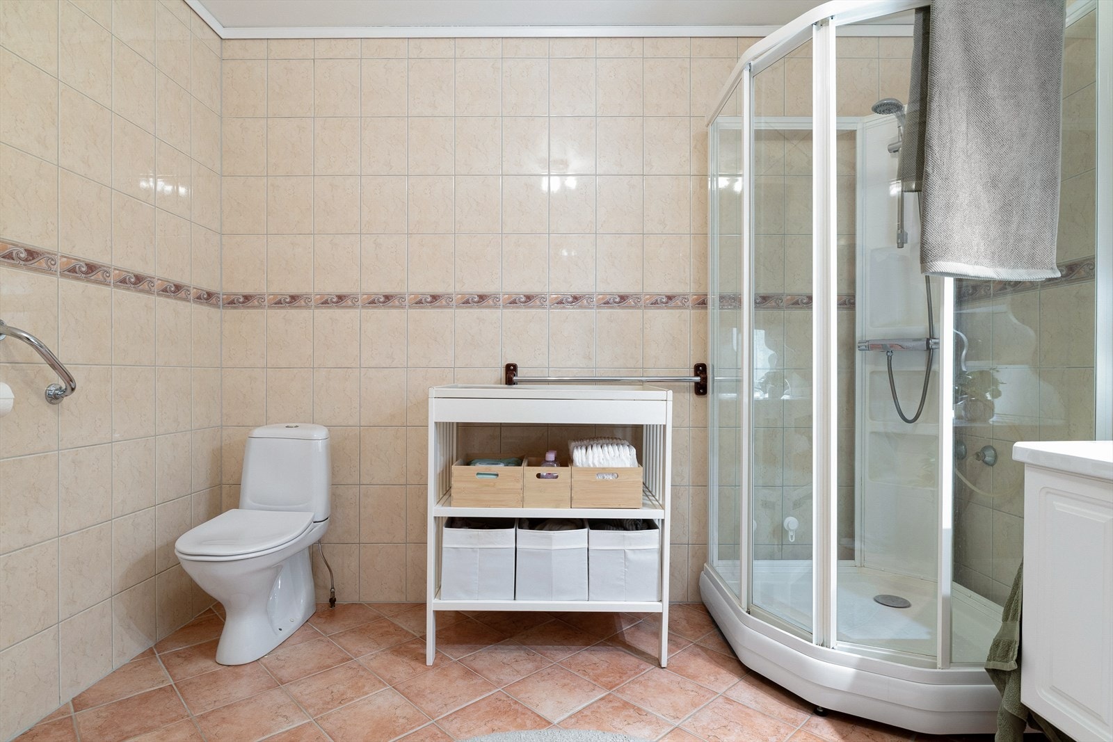 Helfliset bad på 8,3 m² med fliser på gulv og vegger samt malt betonghimling. Galleribilde