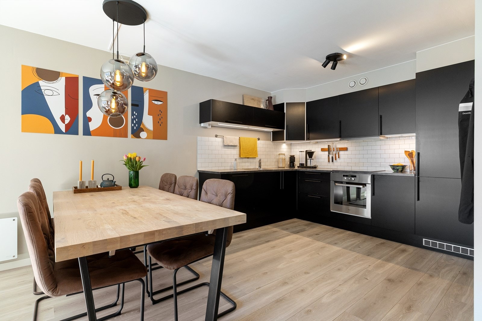 Moderne og funksjonelt kjøkken med glatt laminert kjøkkeninnredning, integrerte hvitevarer og praktisk belysning under overskapene. Galleribilde