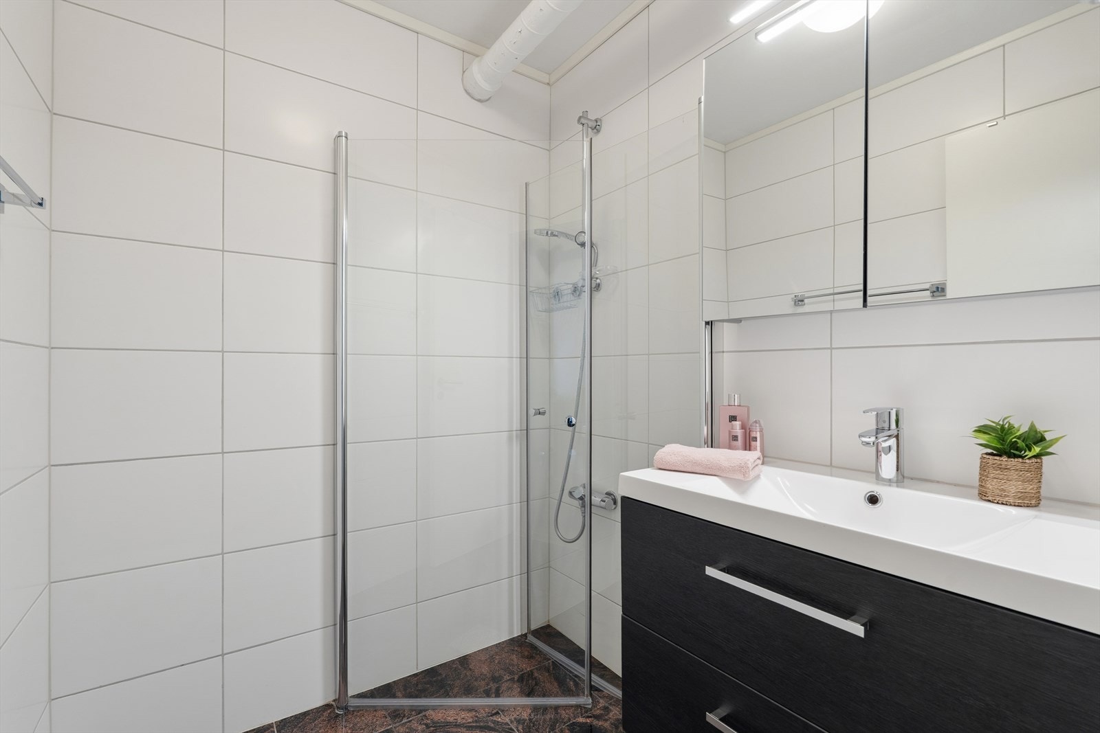 Lekkert flislagt bad fra 2018 med elektrisk gulvvarme - Innredet med servantinnredning og dusjdører Galleribilde