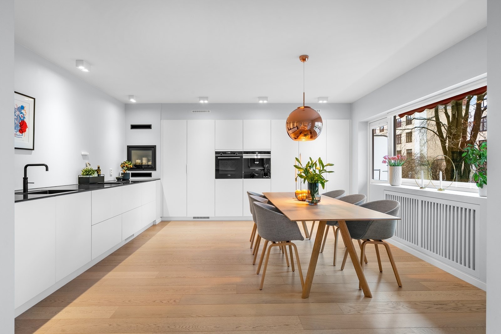 Stort kjøkken/spisestue med Stilren Kvik kjøkkeninnredning fra 2019 med integrerte hvitevarer og benkeplate i steinkompositt. Galleribilde