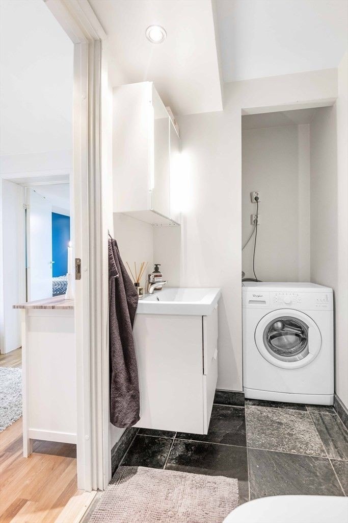 Flott bad som inneholder baderomsinnredning m/servant, opplegg til vaskemaskin, toalett og dusjsone. Galleribilde