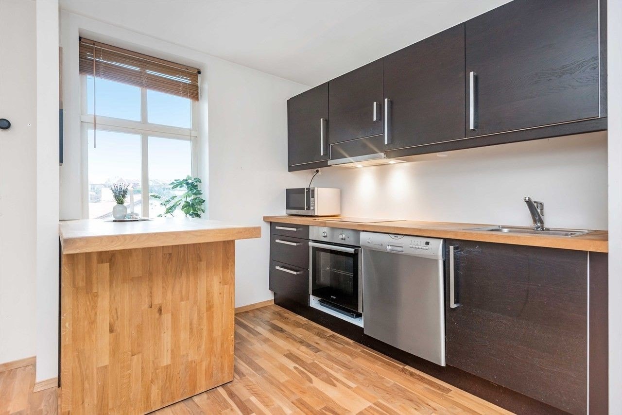 Pent kjøkken med åpen løsning til stue. Galleribilde