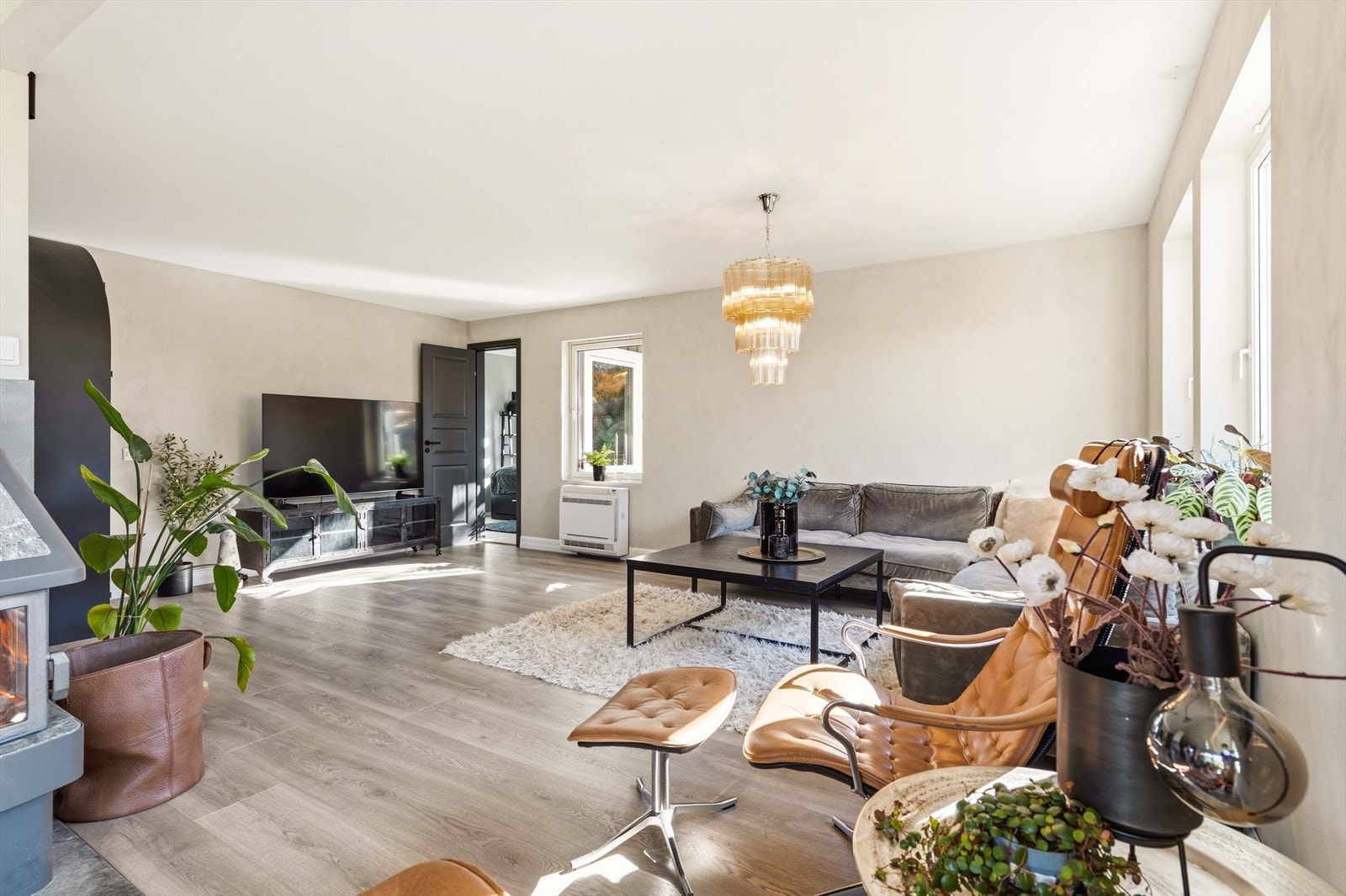 Romslig stue med lun atmosfære og naturlige soner for avslapning og samvær. Store vinduer gir flott utsyn. Galleribilde