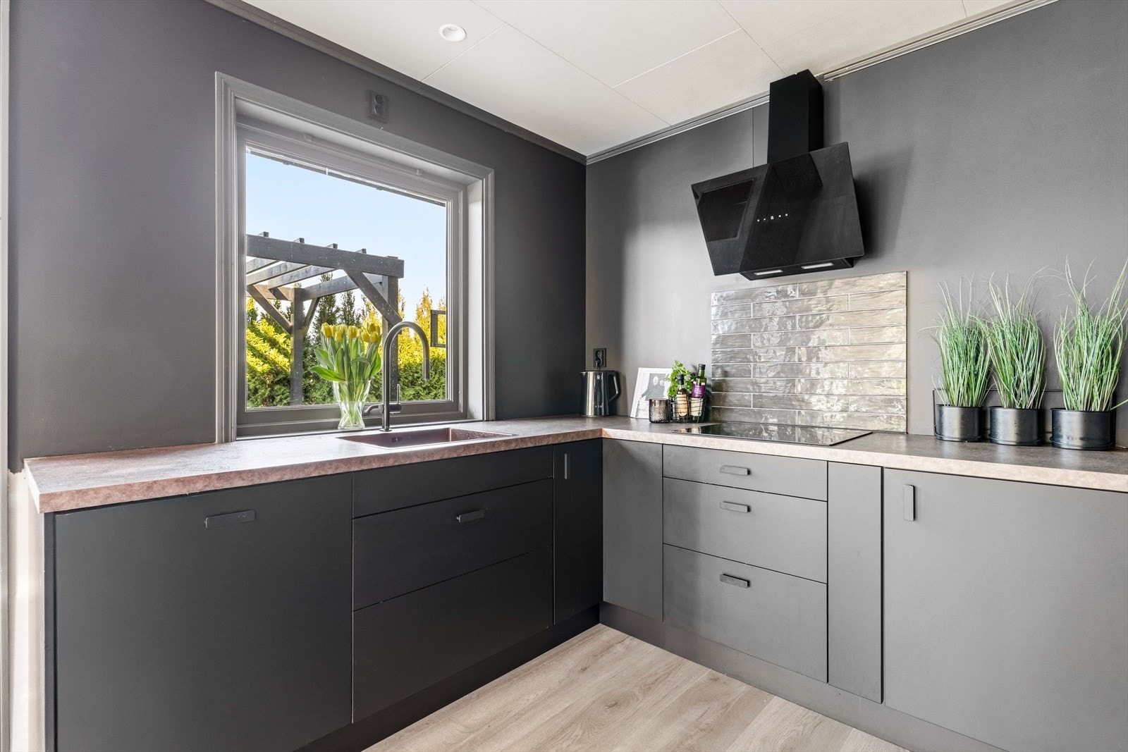 Kjøkken med vindu over benk som gir godt arbeidslys og utsikt. En hyggelig ramme rundt matlagingen. Galleribilde