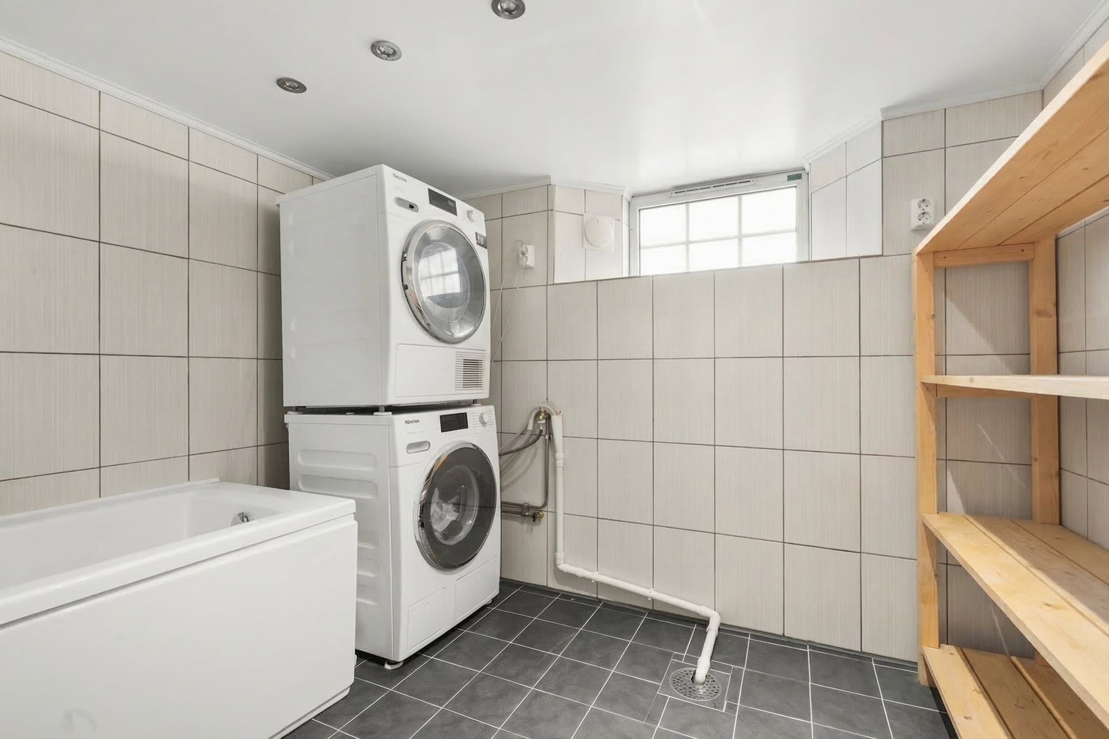 Her er det opplegg for både vaskemaskin og tørketrommel, samt badekar med svingbar dusjvegg. Galleribilde