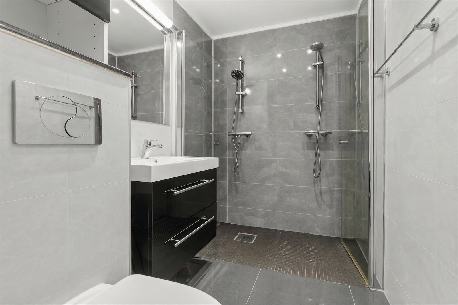 Baderommet fra 2000 har flislagt gulv med gulvvarme og flislagte vegger. Rommet er utstyrt med servant, speil, belysning og vegghengt toalett. En dusjnisje med glassdører og hånddusjer kompletterer rommet. Galleribilde