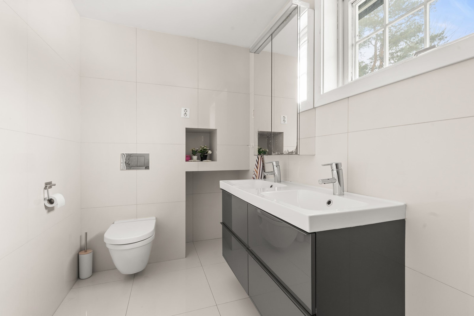 Det moderne baderommet fra 2012 fremstår som både stilrent og funksjonelt. Rommet har flislagt gulv med gulvvarme samt flislagte vegger som gir et tidløst uttrykk. Galleribilde