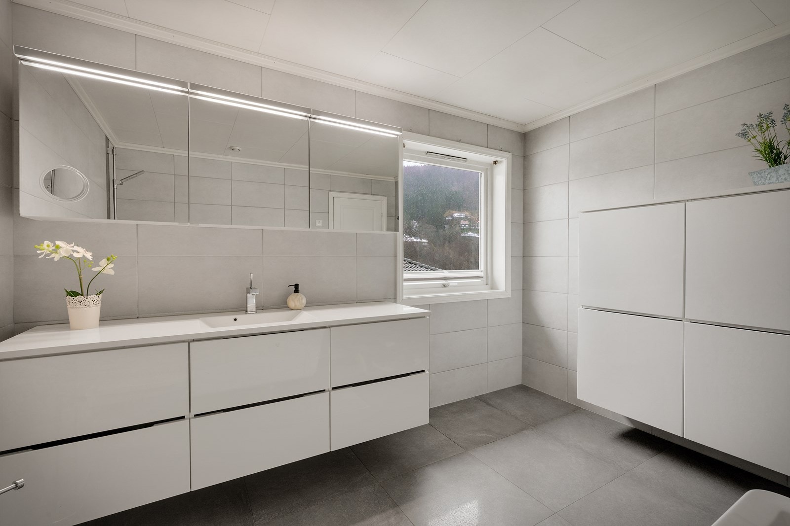 Badet i 2. etasje fremstår som lyst, moderne og romslig, og holder et gjennomgående tidsriktig uttrykk. Rommet ble pusset opp i 2013 av fagfolk | Det er eget vaskerom i underetasjen med utvendig adkomst Galleribilde