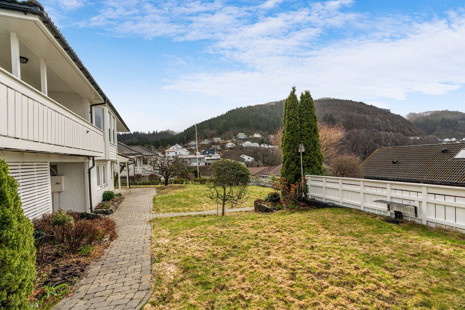 Tomten er opparbeidet med belegningsstein, plen og diverse buskevekster Galleribilde