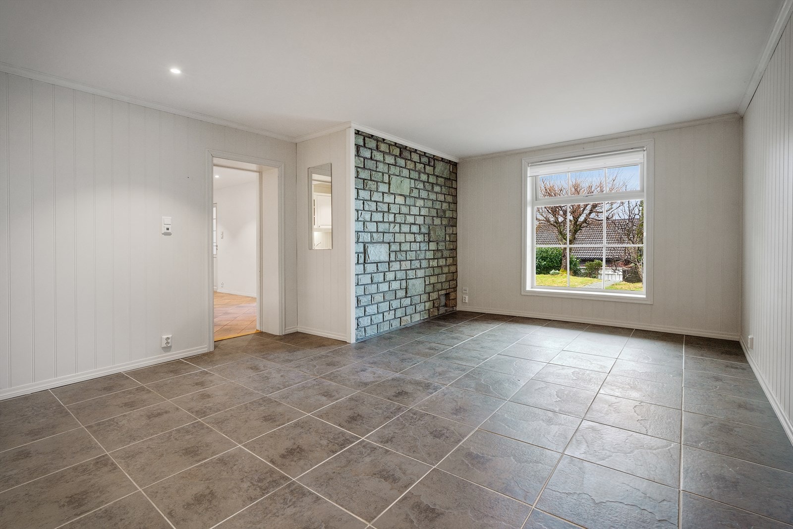 Stuen i underetasjen fremstår som romslig og lys, med en praktisk utforming som gir gode møbleringsmuligheter - varme i gulv Galleribilde