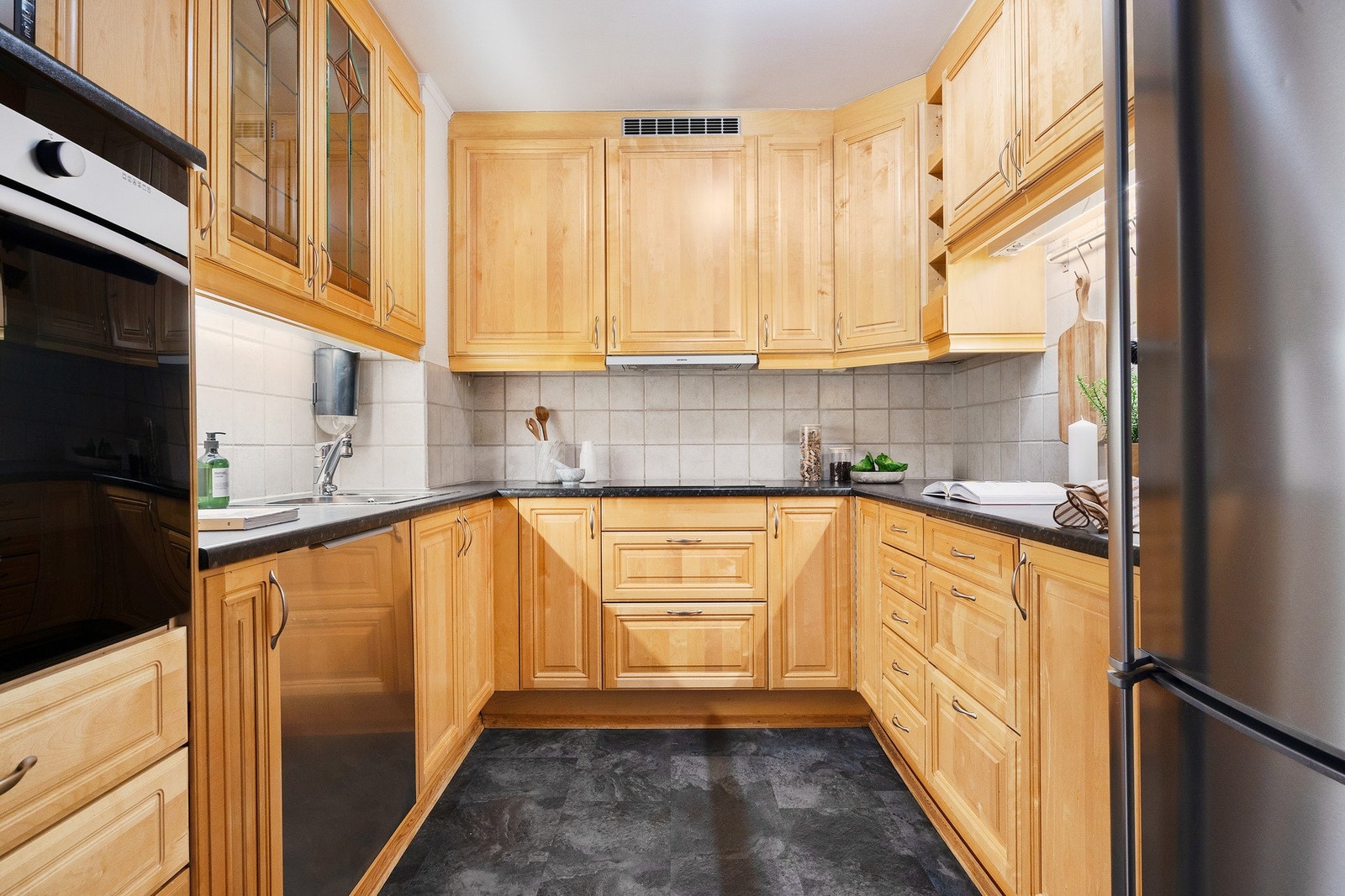 Boligens kjøkken er delvis adskilt fra stuen og du kan enkelt via skyvedøren trekke deg tilbake. Innredning av profilerte fronter, laminat benkeplate og oppvaskkum med ett-greps armatur. Galleribilde