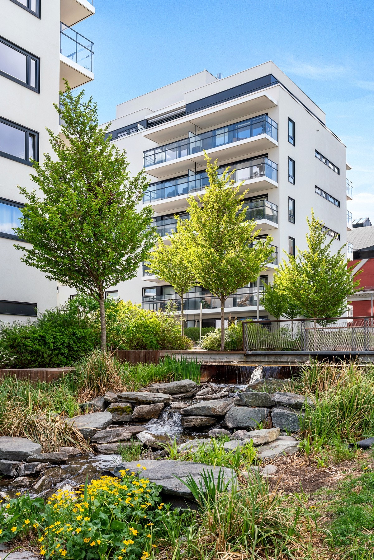 I nærområdet er det anlagt store idylliske grøntarealer, beplantning, bålplasser, bekk, vannspeil og gangbro. Galleribilde