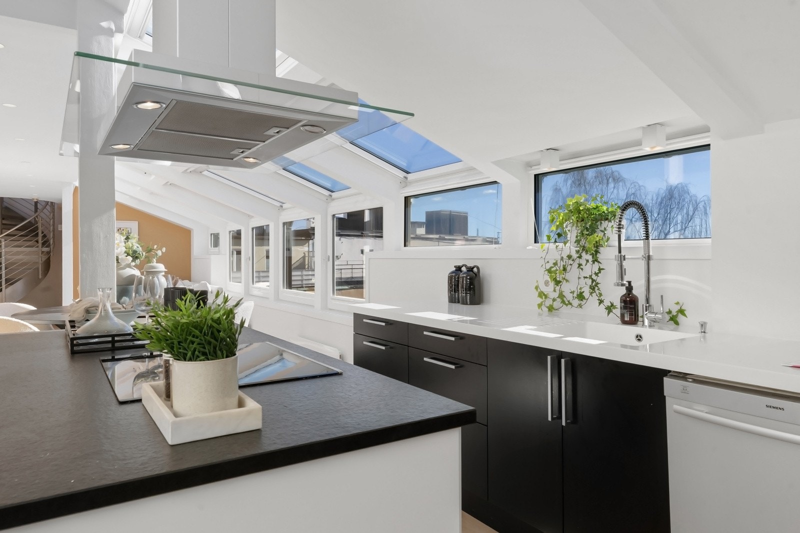 Innholdsrikt kjøkken med benkeplater i corian og stein/kompositt. Galleribilde