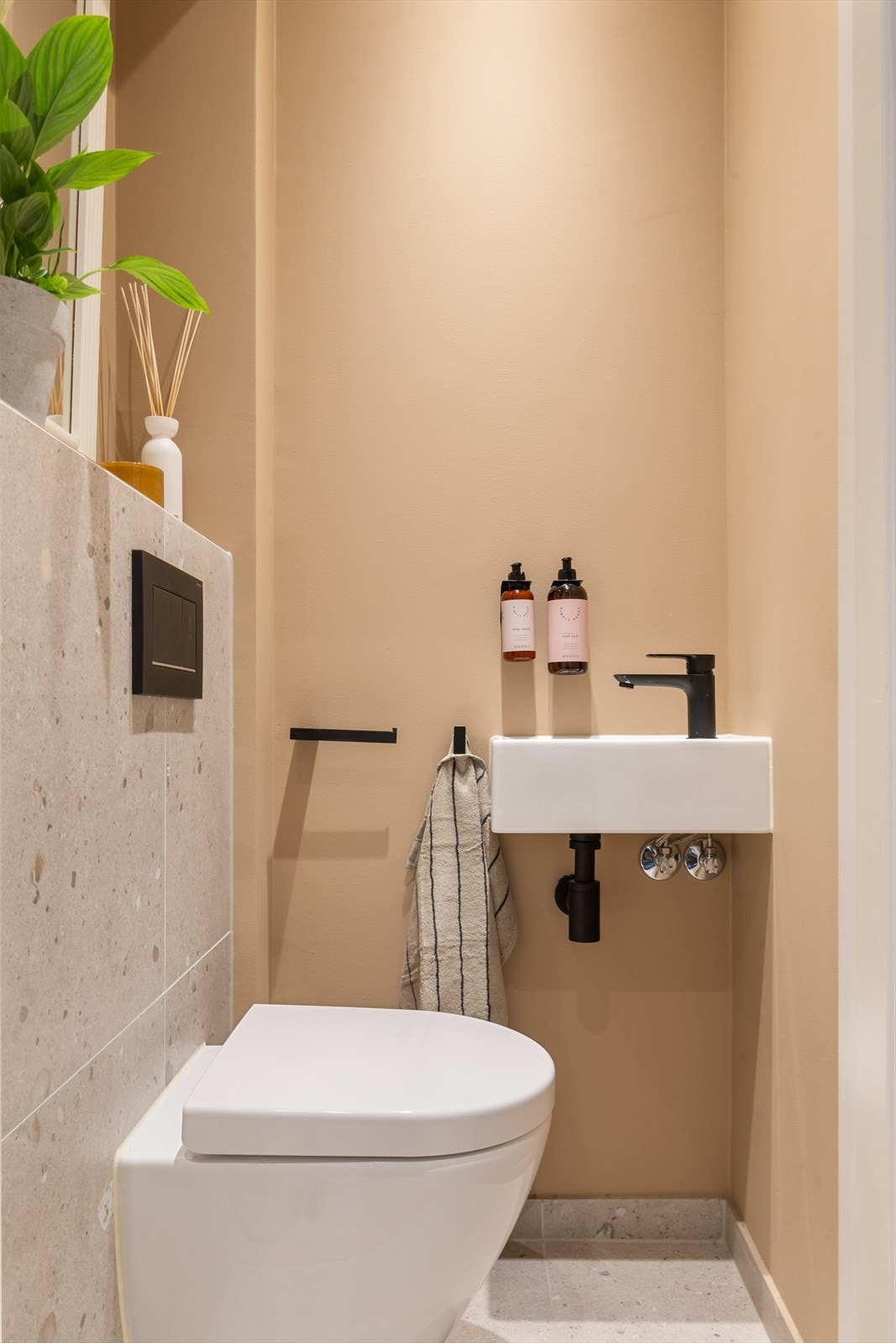 Praktisk gjestetoalett med wc rett ved entréen - vegghengt toalett og servant Galleribilde