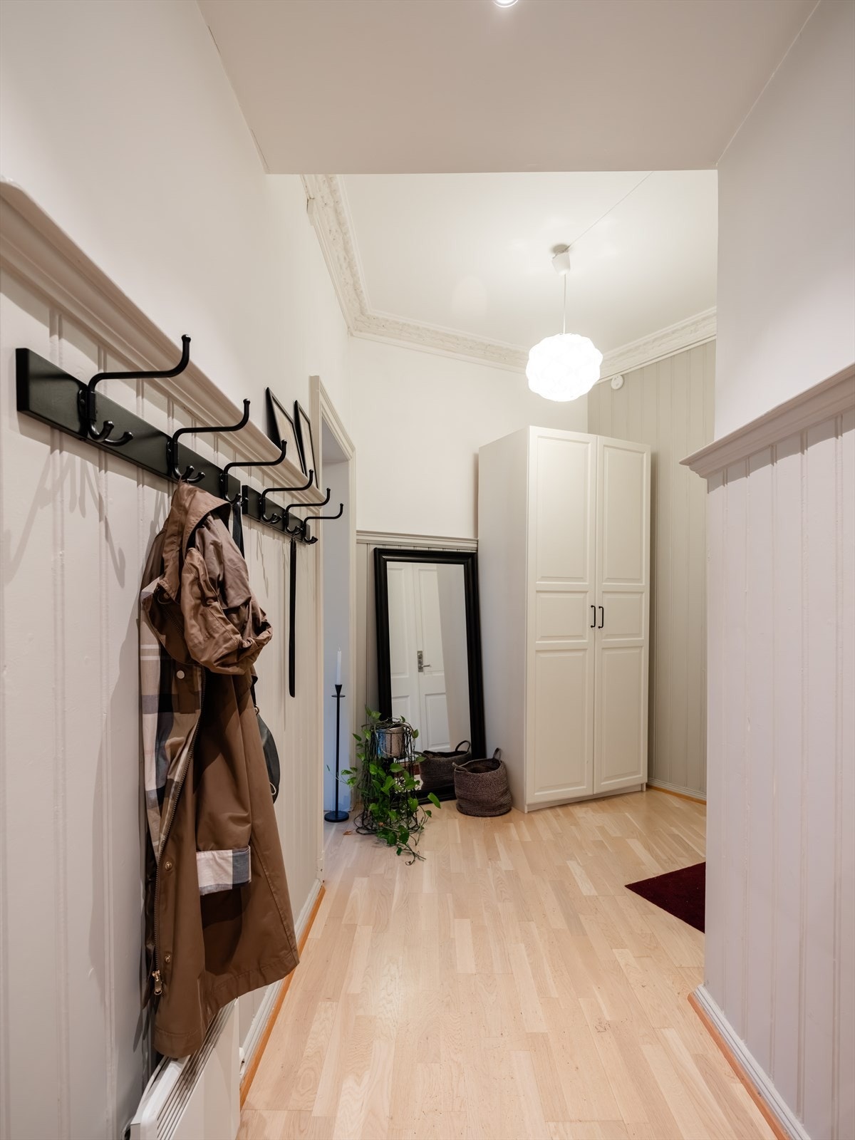Entréen er romslig og gir et godt førsteinntrykk av leiligheten. Her er det rom for å henge fra seg yttertøy og sko i praktisk garderobe. Galleribilde