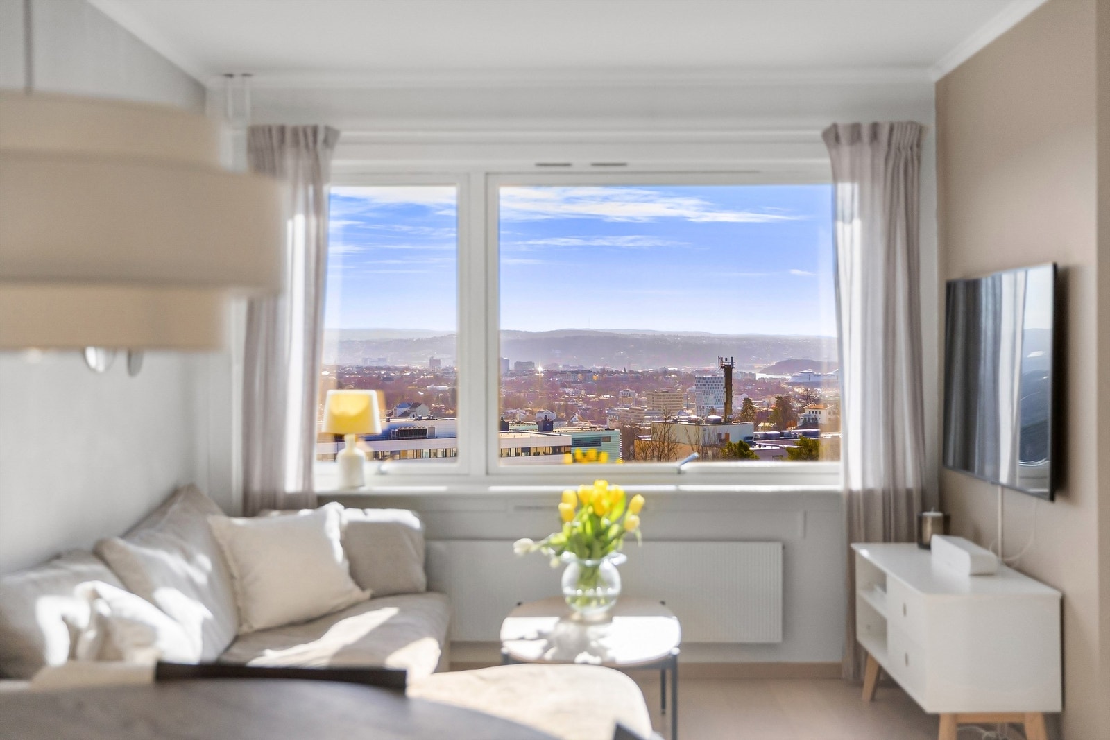 Stuen har god plass til både sofagruppe, spisebord og vitrineskap. Flott utsikt utover Oslo by og fjord Galleribilde