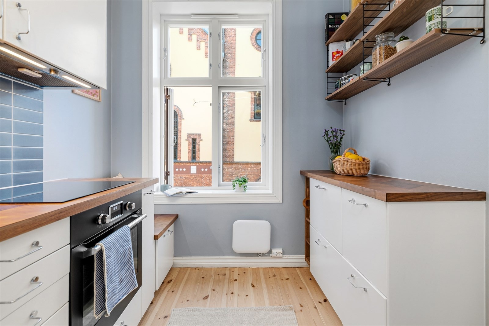 Veggene er malt i fargen Isblå fra Fargerike og harmonerer pent med de blå flisene mellom over- og underskap. Galleribilde