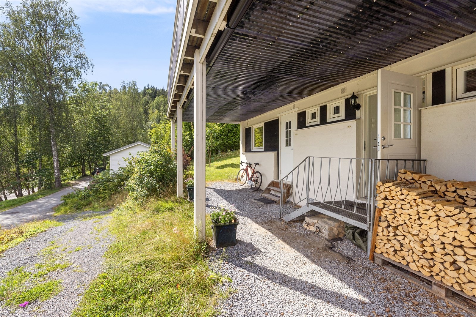 Overbygget inngangsparti, med plass til å parkere sykler e.l. utenfor Galleribilde