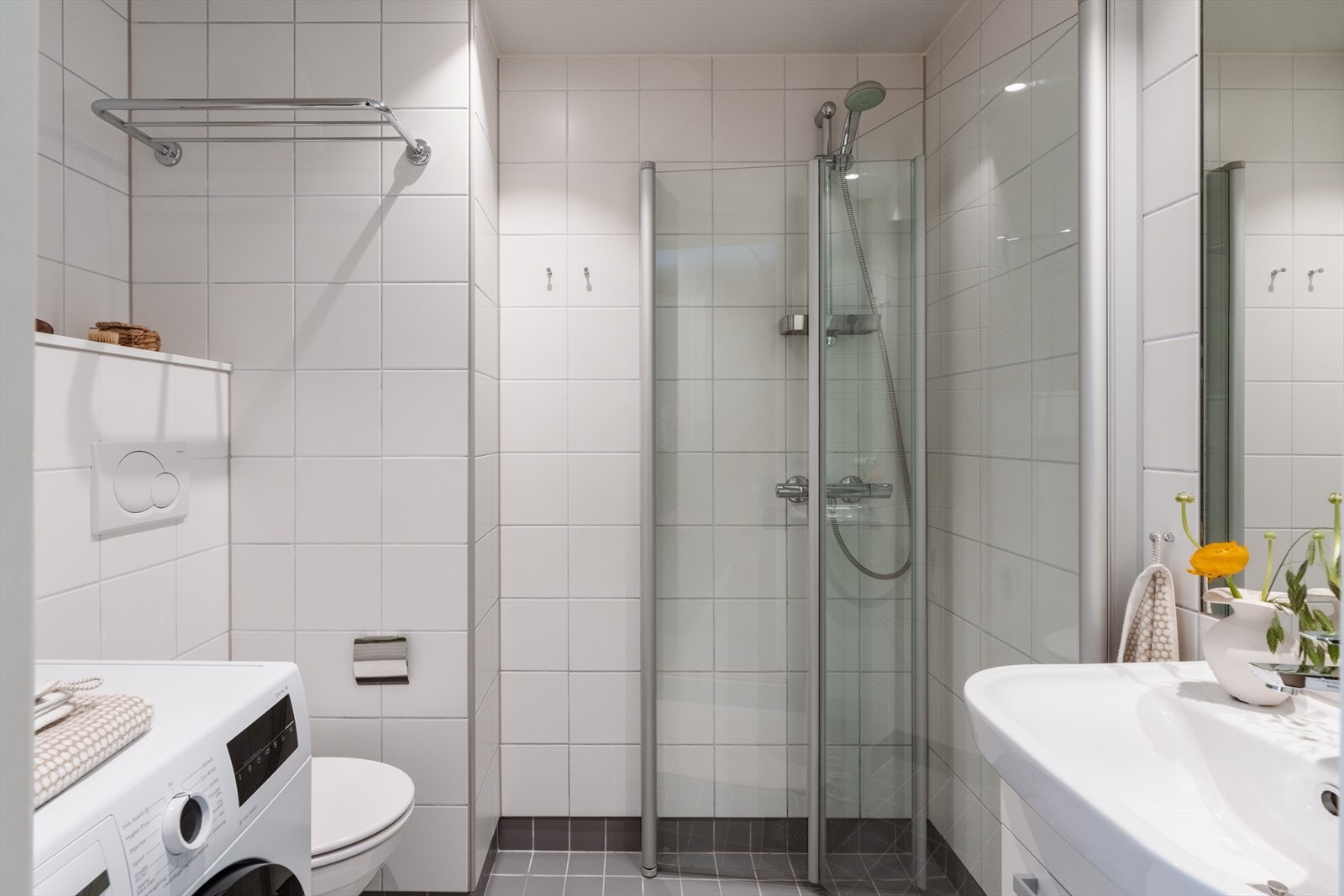 Praktisk bad med god standard fra byggeår, med hvite fliser på vegg og delikat innredning Galleribilde