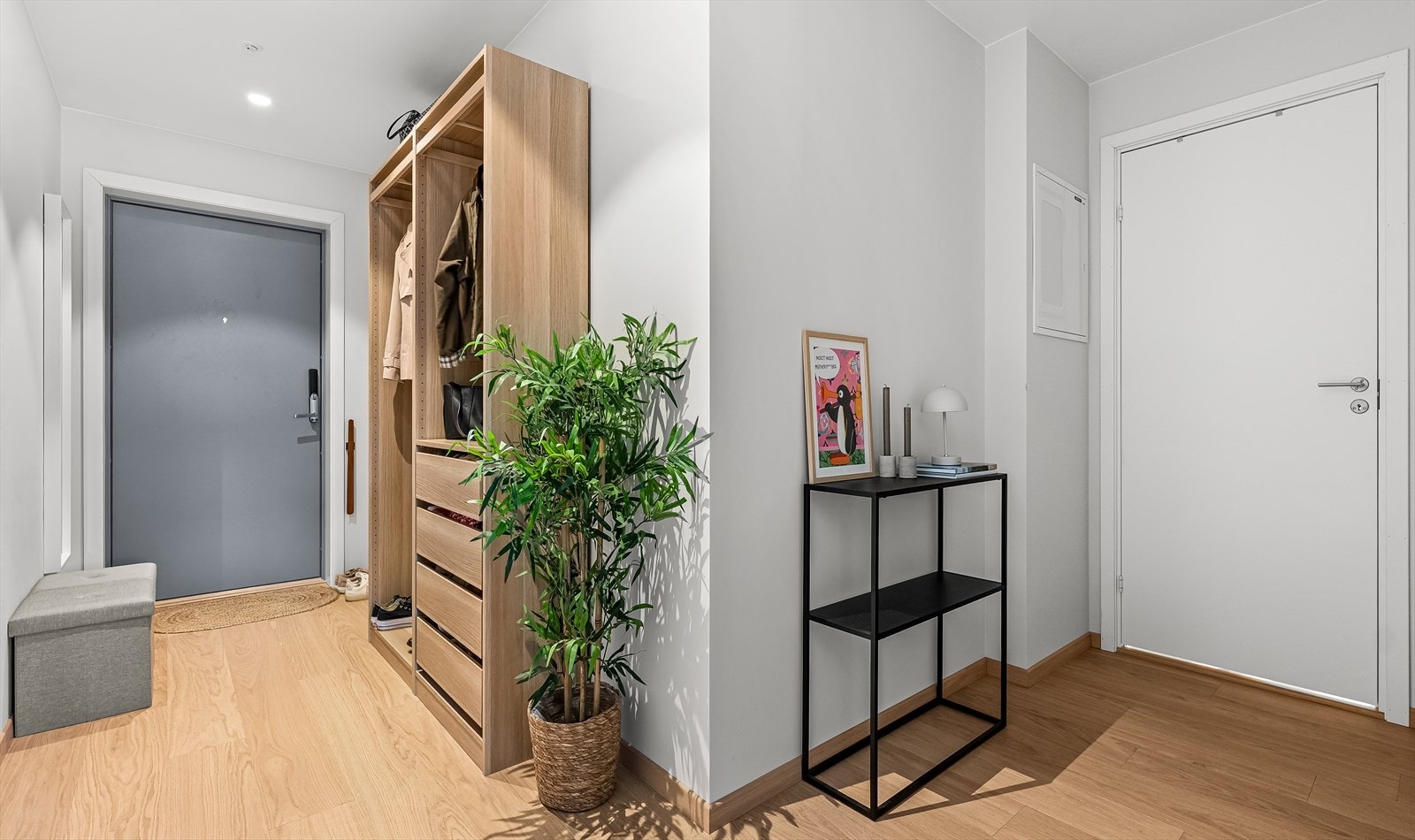 Romslig og nnbydende entré med god plass til oppbevaring av yttertøy og sko, med praktisk planløsning som gir tilgang til leilighetens øvrige rom. Galleribilde