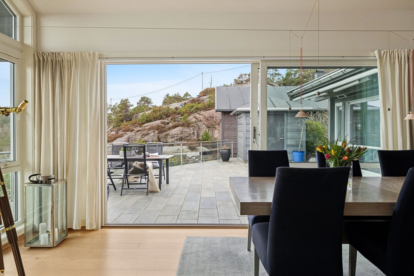 Ved spistestuen åpner store skyvedører opp mot den skiferbelagte terrassen. Galleribilde