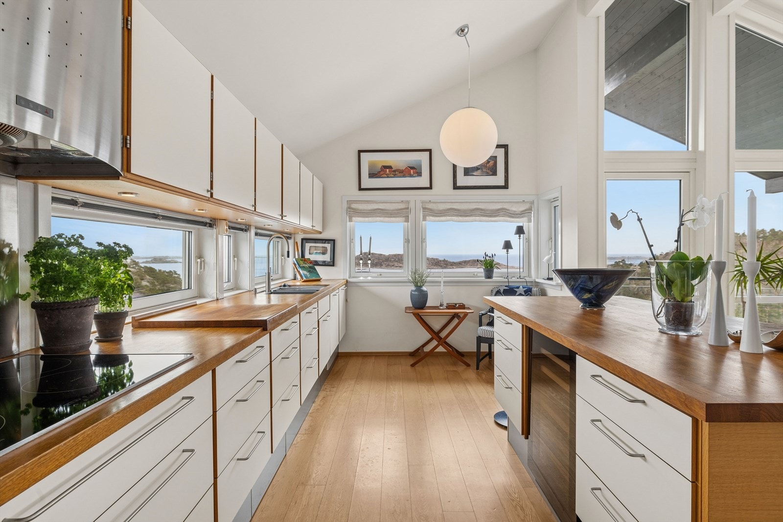 Gjennomgående parkett på gulv og store vindusflater skaper en lys og luftig atmosfære i hele oppholdsrommet. Galleribilde